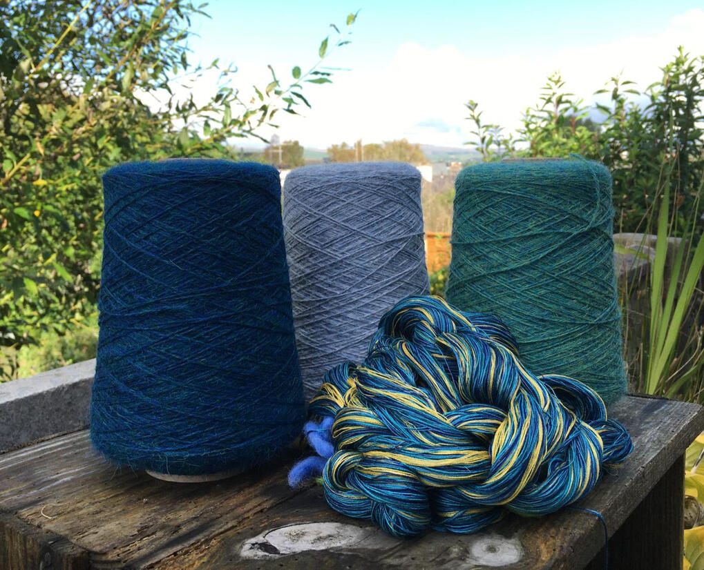 Spools of blue yarn with scenic Cumbria landscape in the background – natural textile inspiration